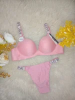Flat lay of the Xelxia Rose Pink bra and panty set showing ribbed fabric texture and crystal details.